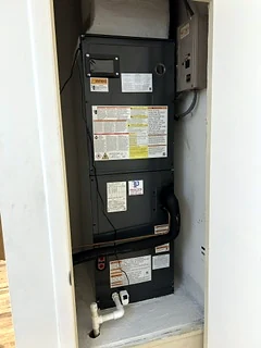 New air handler installed in a closet with its service disconnect.