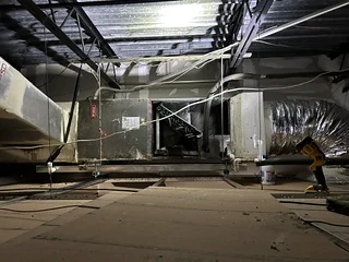 Commercial air handler and ductwork above an open ceiling during a no-cool service call.