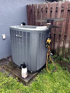 Outdoor condenser coil being cleaned during a maintenance tune-up.