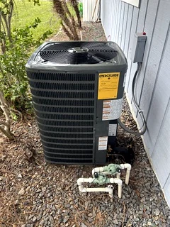 Newly installed outdoor air conditioning condenser beside a house.