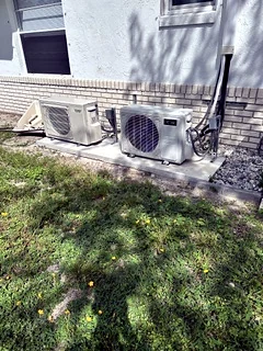 Two mini-split outdoor units installed on a pad.